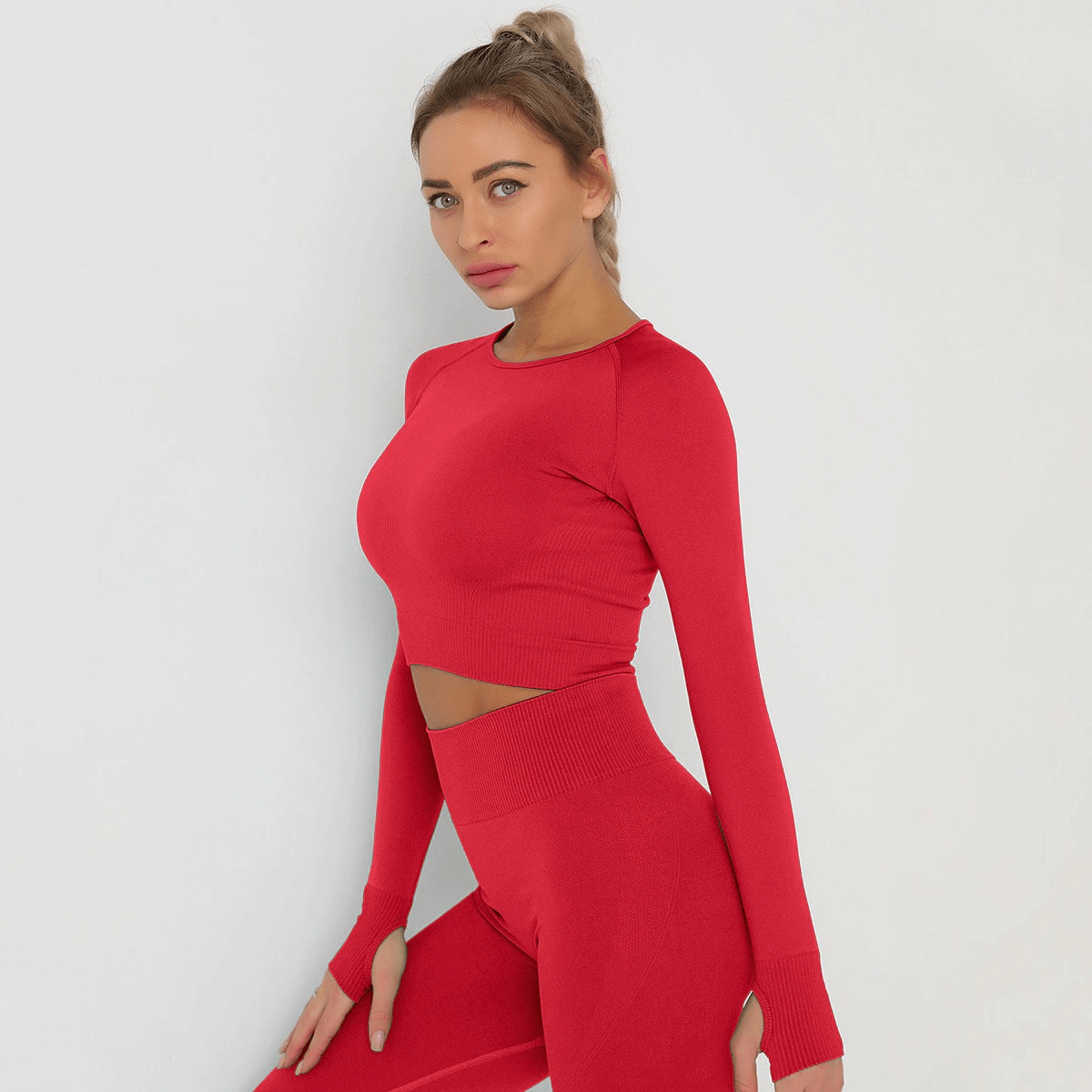 Model wearing a red long sleeve sports crop top made from breathable nylon and spandex, perfect for yoga and running.